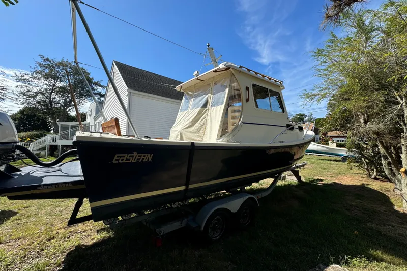 Slide: The Image of 2009 Eastern 24 boat on trailer, parked outdoors under clear blue sky. - 10