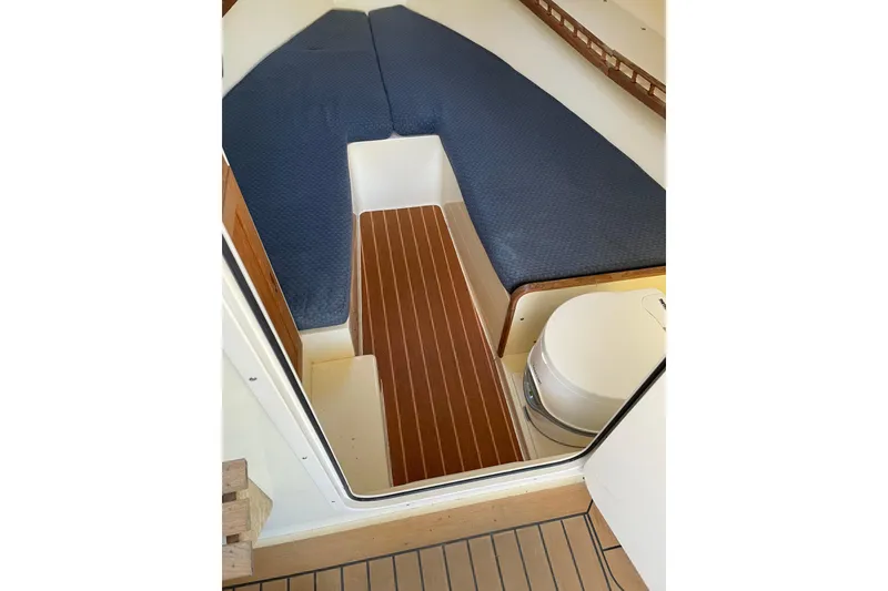 Slide: The Image of Interior cabin of 2009 Eastern 248 Explorer boat with blue cushions and wooden flooring. - 13