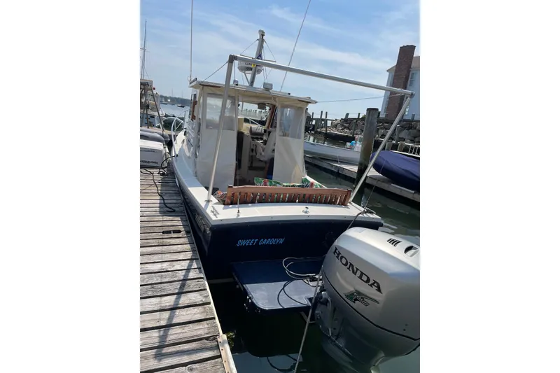 Slide: The Image of 2009 Eastern 248 Explorer boat docked with Honda outboard motor. - 14