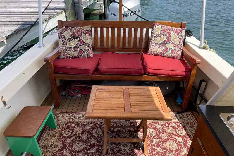 Slide: The Image of Cozy seating area on 2009 Eastern 248 Explorer boat with red cushions and wooden table. - 2