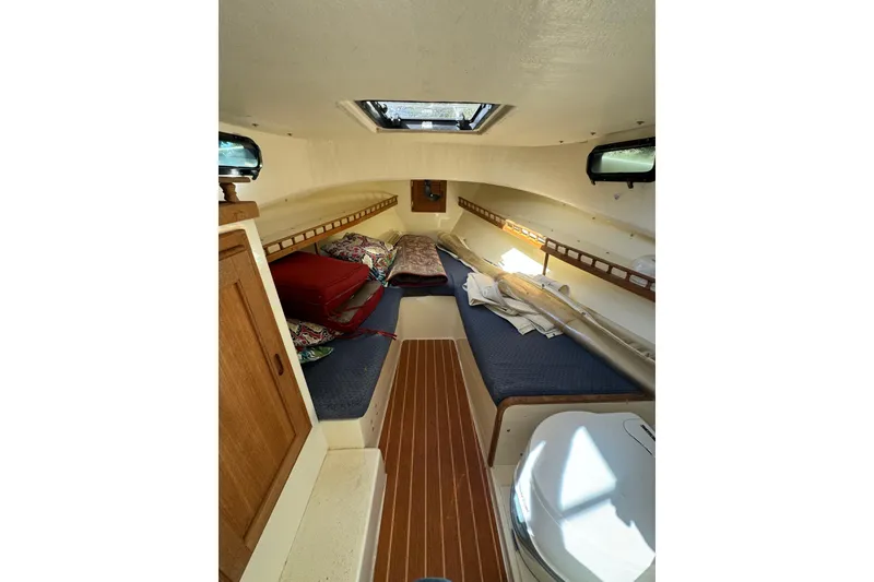 Slide: The Image of Cozy cabin interior of 2009 Eastern 24 boat with wooden accents and bedding. - 3