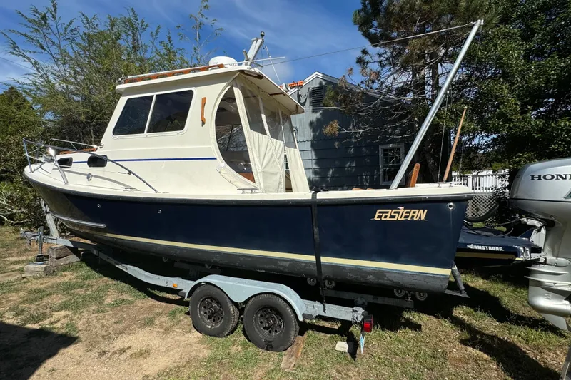 Slide: The Image of 2009 Eastern 24 boat on trailer, parked outdoors, with Honda outboard motor. - 9