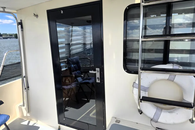 Slide: The Image of Nordic Tug 42 Flybridge 2000 boat deck with glass door and life preserver. - 13