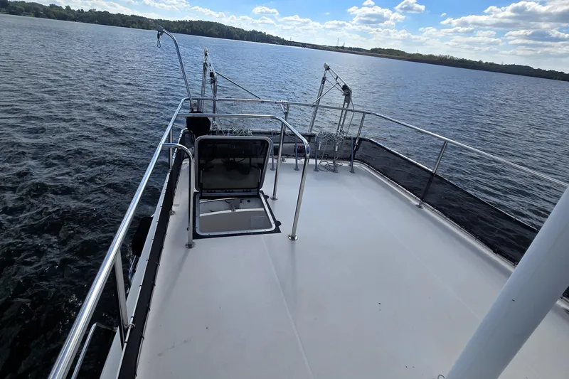 Slide: The Image of Nordic Tug 42 Flybridge 2000 on calm water, featuring spacious deck and open hatch. - 14