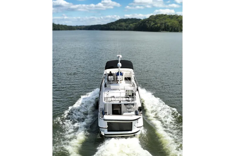 Slide: The Image of 2000 Nordic Tug 42 Flybridge cruising on a scenic lake under a blue sky. - 3