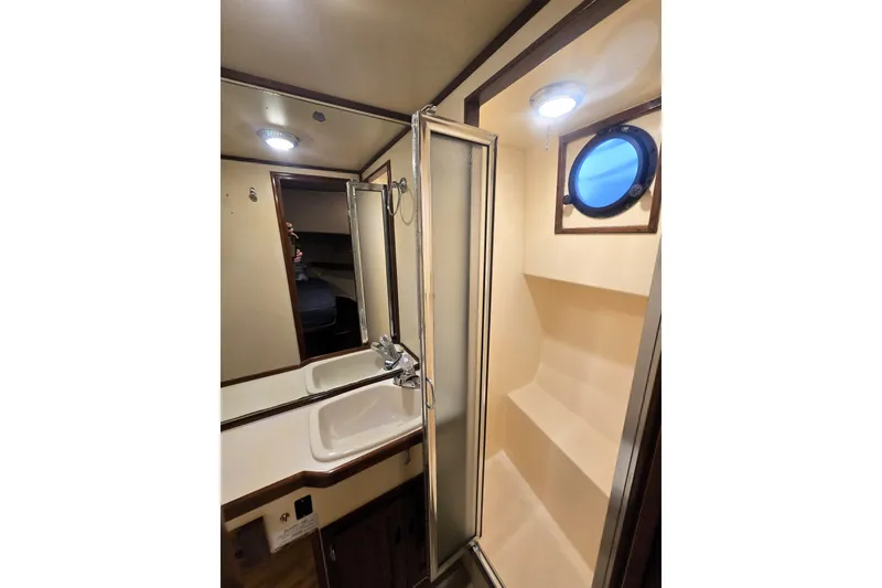 Slide: The Image of Bathroom interior of 2000 Nordic Tug 42 Flybridge with shower and porthole. - 30