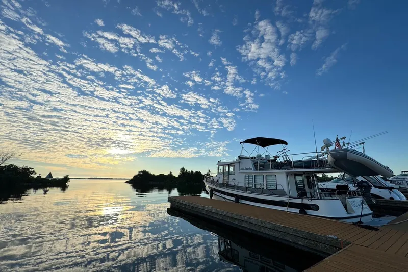 Slide: The Image of Nordic Tug 42 Flybridge 2000 docked at sunset with scenic sky and water reflections. - 10