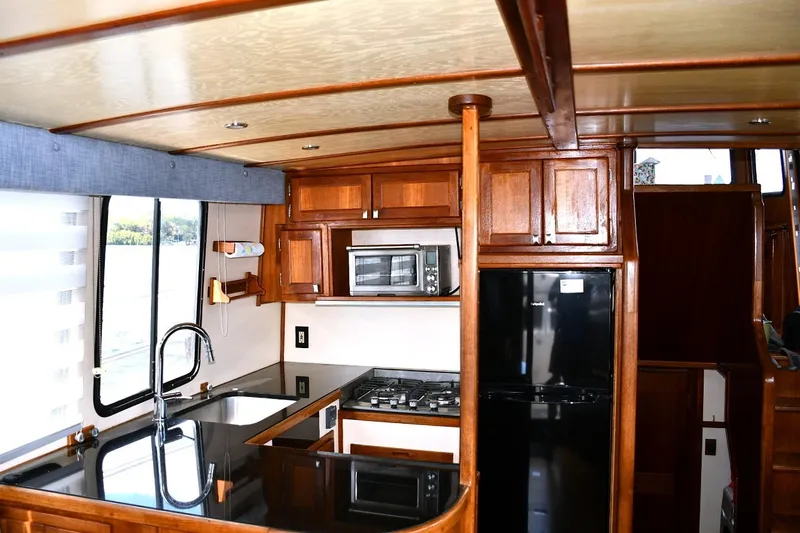 Slide: The Image of Luxurious kitchen interior of 2000 Nordic Tug 42 Flybridge with wood cabinetry and modern appliances. - 27