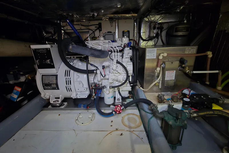 Slide: The Image of Engine room of a 2000 Nordic Tug 42 Flybridge, featuring mechanical components and wiring. - 42