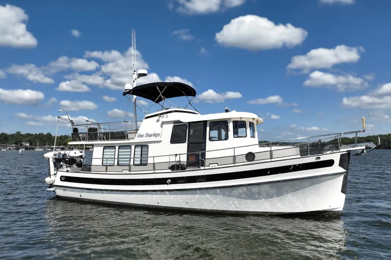 Slide: The Image of Nordic Tug 42 Flybridge 2000 on calm water under a blue sky with clouds. - 8