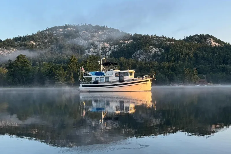 Slide: The Image of Nordic Tug 42 Flybridge 2000 on misty lake with forested mountain backdrop. - 9