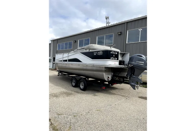 Slide: The Image of 2019 G3 SunCatcher V22 pontoon boat on trailer, parked outside a building. - 2