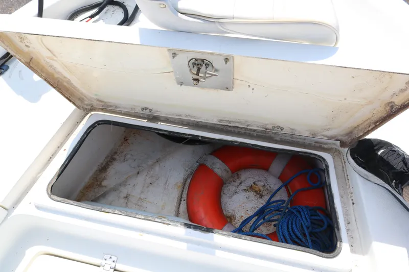 Slide: The Image of Open storage compartment on 2005 NauticStar 2200 Nautic Bay boat with life preserver and rope. - 16