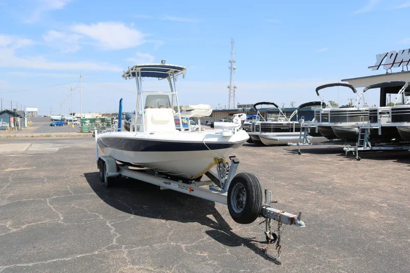 Slide: The Image of 2005 NauticStar 2200 Nautic Bay boat on trailer in parking lot, clear sky background. - 2