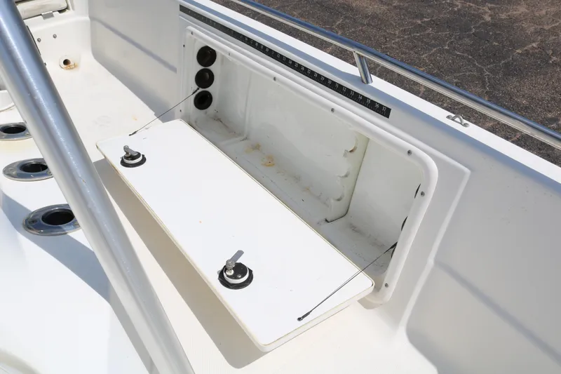 Slide: The Image of 2005 NauticStar 2200 Nautic Bay boat interior with storage compartment and rod holders. - 22