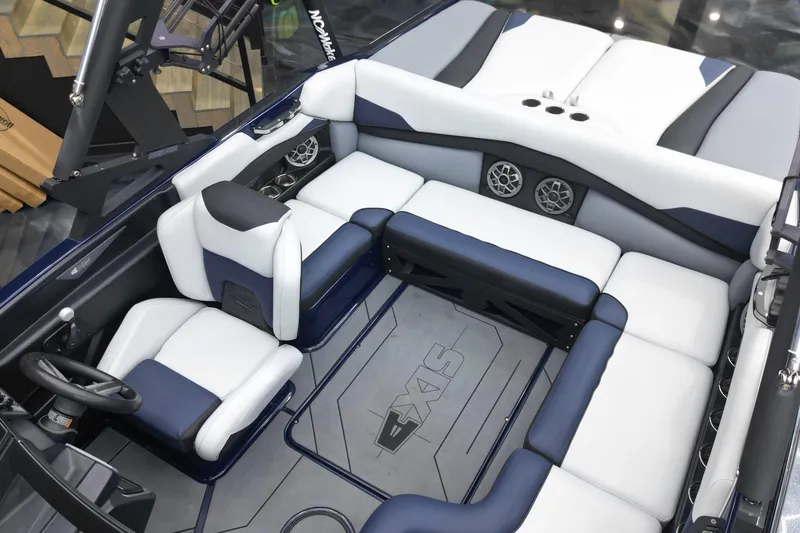 Slide: The Image of 2019 Axis A20 boat interior with white and navy seating, featuring speakers and steering wheel. - 9