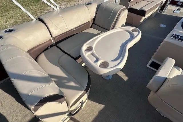 Slide: The Image of 2018 Sun Tracker SportFish 22 DLX interior with beige seating and oval table. - 12