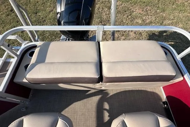 Slide: The Image of 2018 Sun Tracker SportFish 22 DLX boat with cushioned seating and outboard motor. - 16