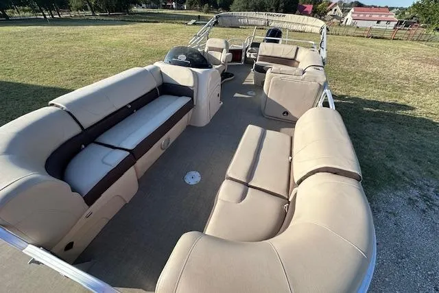 Slide: The Image of 2018 Sun Tracker SportFish 22 DLX pontoon boat with spacious seating on grassy area. - 9