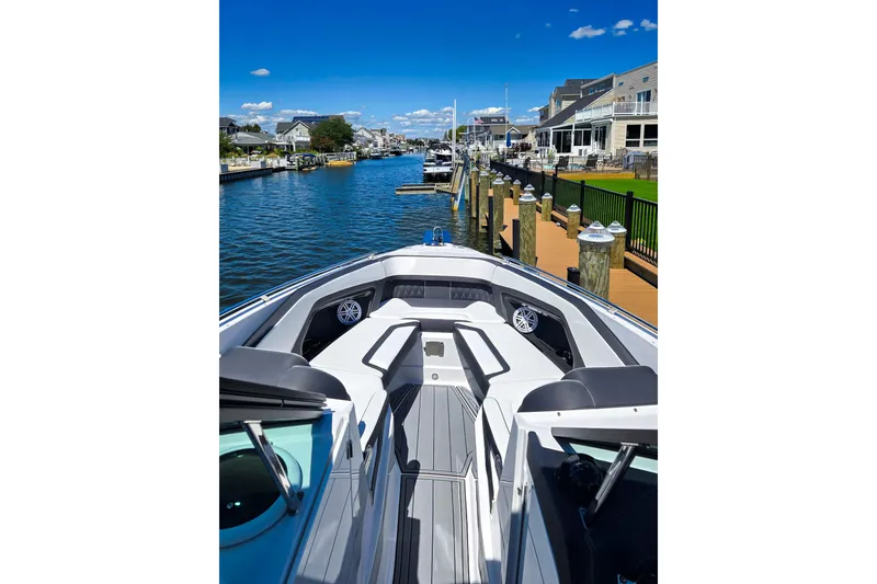 Slide: The Image of 2024 Monterey 305SS Super Sport boat docked in a scenic waterfront neighborhood. - 6