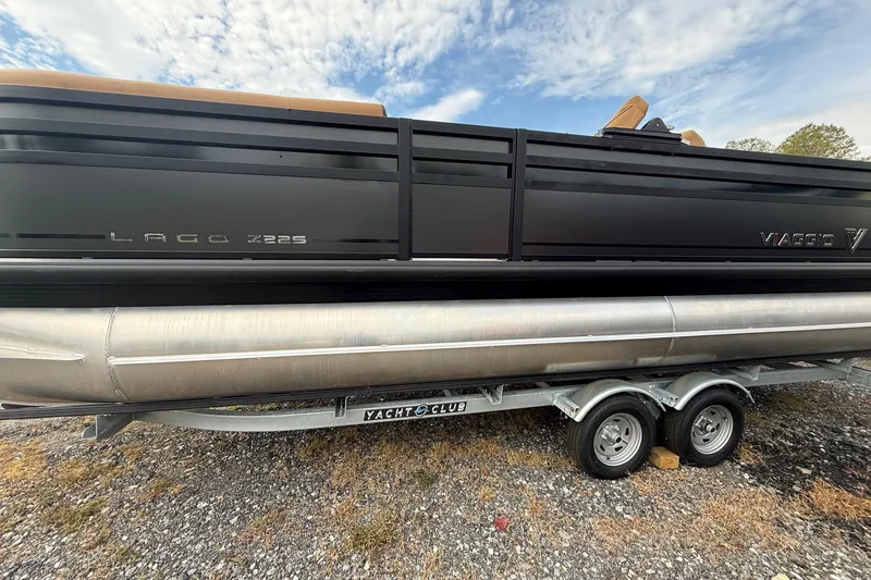 The Image of 2026 Viaggio Lago Z22S-CC pontoon boat on trailer, under a partly cloudy sky. - 0