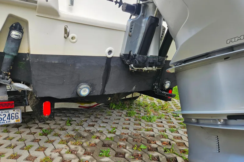Slide: The Image of 2019 Boston Whaler 230 Outrage boat stern with outboard motor and trailer. - 24