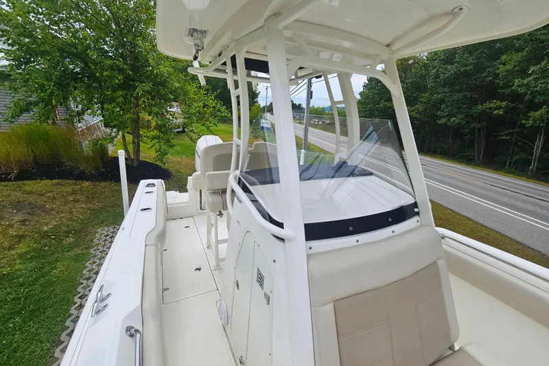 Slide: The Image of 2019 Boston Whaler 230 Outrage boat with sleek design, parked near a road and greenery. - 9