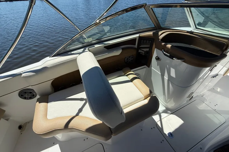 Slide: The Image of 2018 Cobalt 23SC boat interior with tan seating and sleek dashboard design. - 11