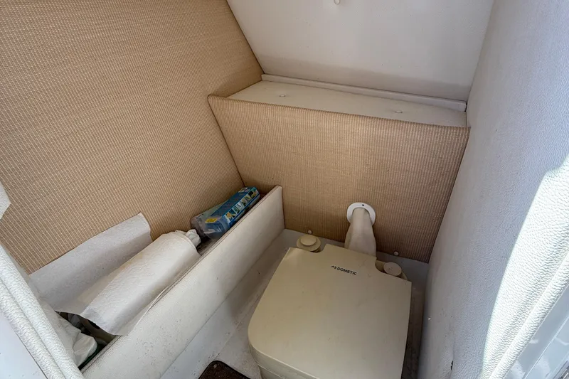 Slide: The Image of 2018 Cobalt 23SC boat interior with compact toilet and storage area. - 14