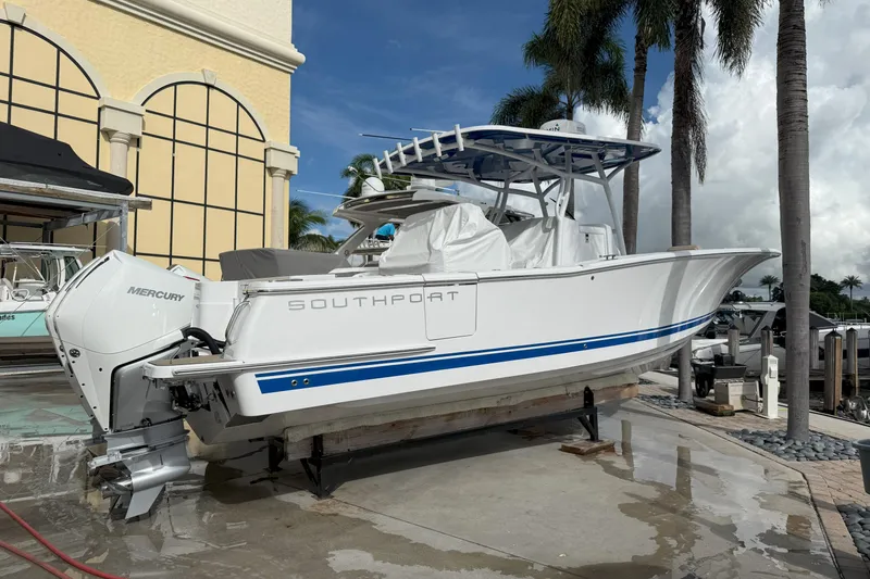 The Image of 2024 Southport 30 FE boat with Mercury engine, docked near palm trees. - 0