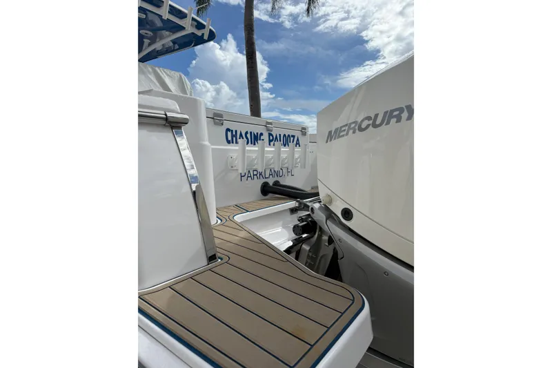 Slide: The Image of 2024 Southport 30 FE boat with Mercury engine, docked under a blue sky. - 10