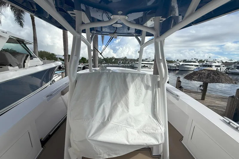 Slide: The Image of 2024 Southport 30 FE boat interior with covered seating, docked at a marina. - 22