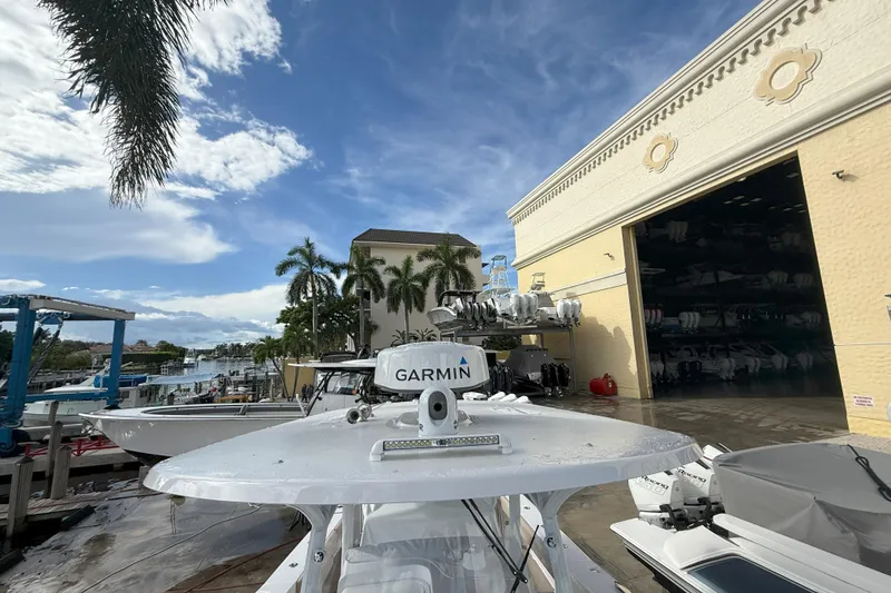 Slide: The Image of 2024 Southport 30 FE boat docked near a marina with palm trees and clear sky. - 31