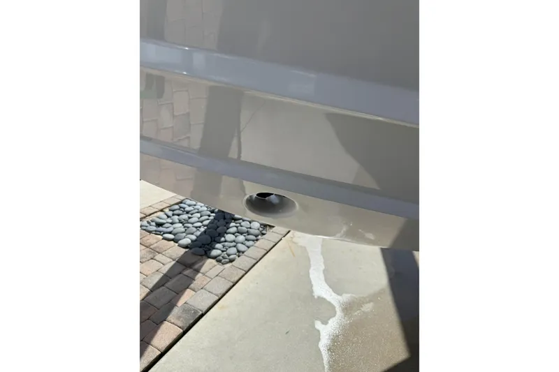 Slide: The Image of 2024 Southport 30 FE boat hull detail with drain plug, outdoor setting. - 5