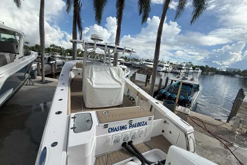 Slide: The Image of 2024 Southport 30 FE boat docked at marina with palm trees and cloudy sky. - 9