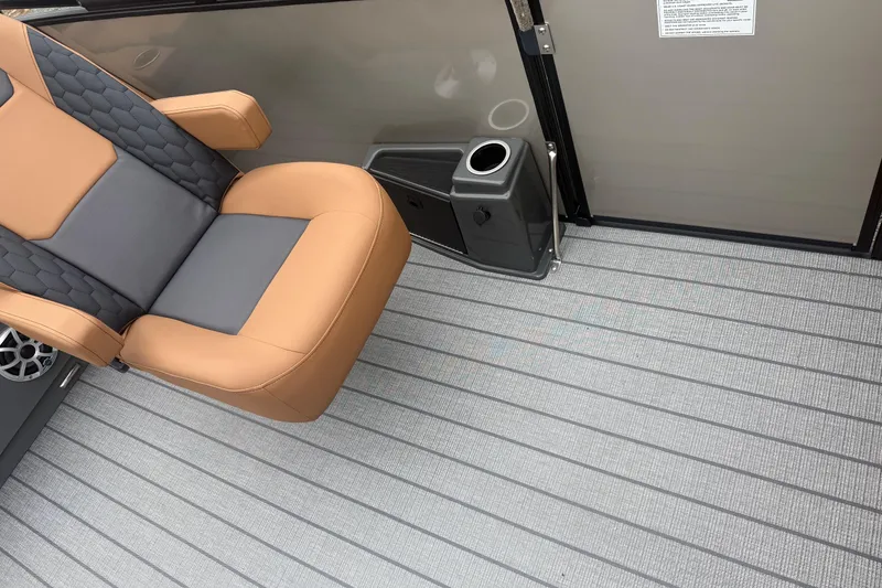 Slide: The Image of 2026 Sylvan L-3 DLZ DH boat interior with tan and gray seating, cup holder, and striped flooring. - 14