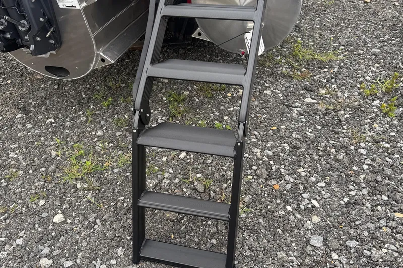 Slide: The Image of Folding ladder attached to a 2026 Sylvan L-3 DLZ DH boat on gravel. - 24