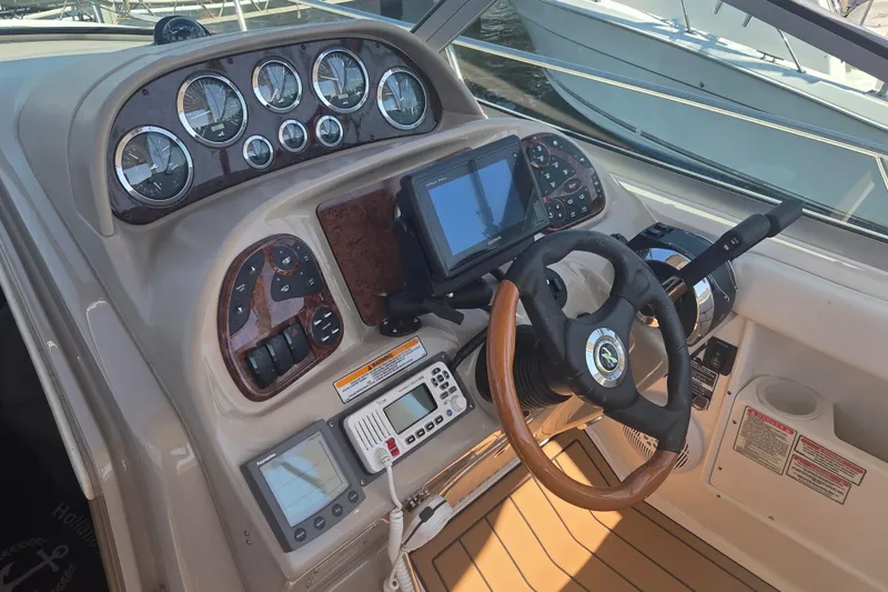 Slide: The Image of 2003 Sea Ray 300 Sundancer helm with gauges, GPS, and controls. - 10