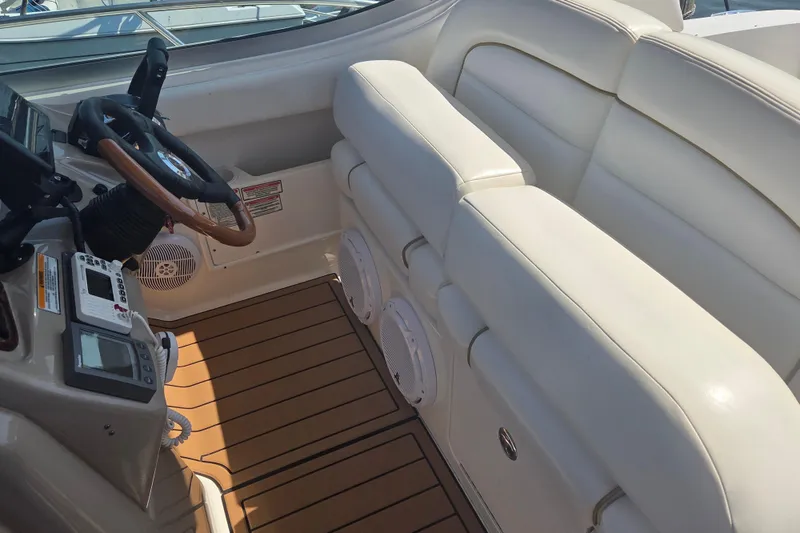 Slide: The Image of Interior of 2003 Sea Ray 300 Sundancer boat with white seating and wooden steering wheel. - 11
