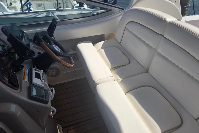 Slide: The Image of 2003 Sea Ray 300 Sundancer cockpit with white seating and navigation controls. - 13