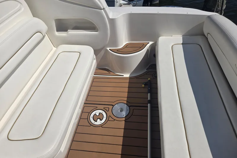 Slide: The Image of 2003 Sea Ray 300 Sundancer boat interior with cushioned seating and teak flooring. - 18