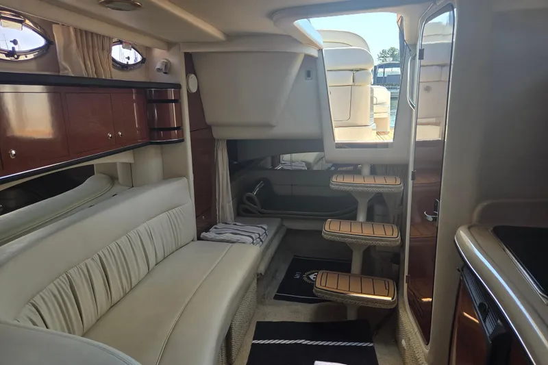 Slide: The Image of Interior of 2003 Sea Ray 300 Sundancer yacht with elegant seating and wooden cabinetry. - 22