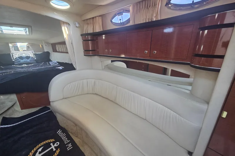 Slide: The Image of Interior of 2003 Sea Ray 300 Sundancer with plush seating and elegant wood cabinetry. - 27