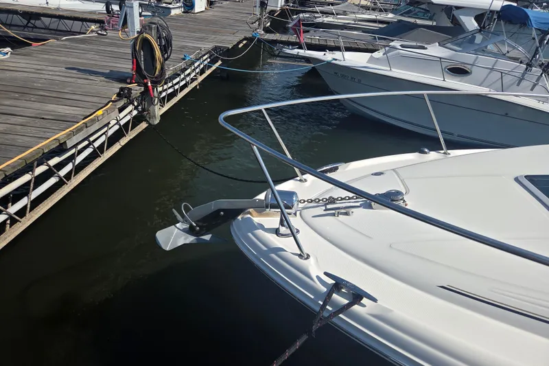 Slide: The Image of 2003 Sea Ray 300 Sundancer docked at marina, showing bow and anchor. - 35