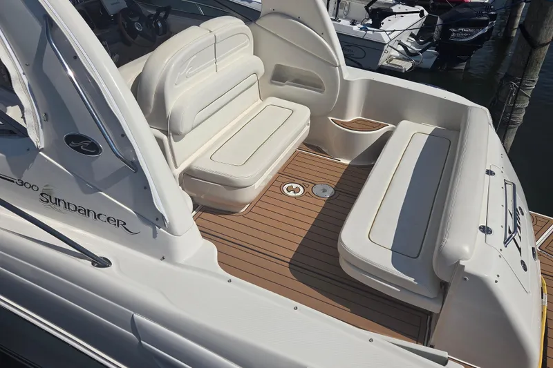 Slide: The Image of 2003 Sea Ray 300 Sundancer boat interior with white seating and teak flooring. - 5