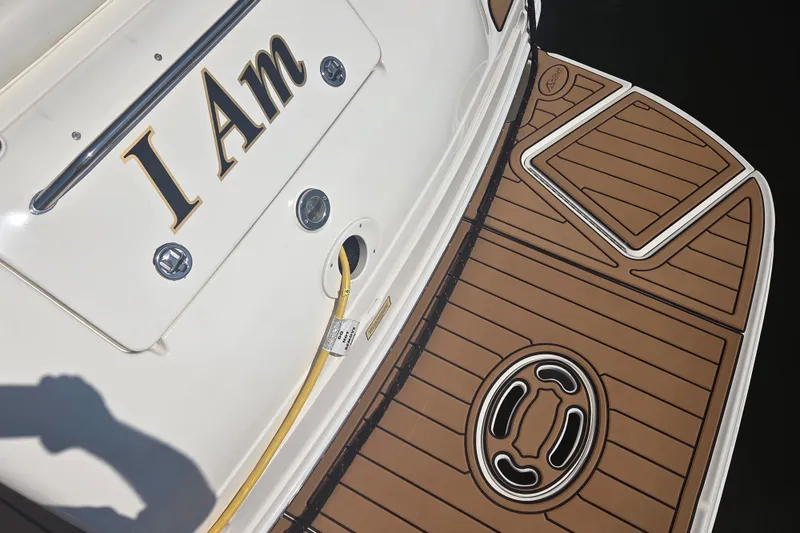Slide: The Image of 2003 Sea Ray 300 Sundancer boat with "I Am" nameplate and teak-style deck. - 9