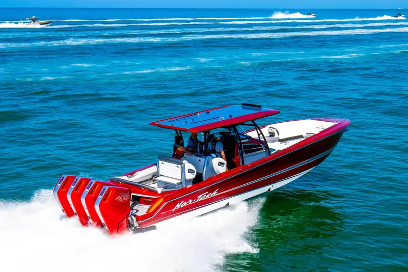 The Image of 2025 Nor-Tech 390 Sport boat speeding on ocean with vibrant red design. - 0