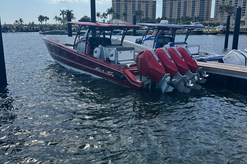 Slide: The Image of 2025 Nor-Tech 390 Sport boat with four powerful engines docked in a marina. - 10