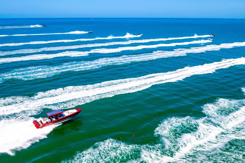 Slide: The Image of 2025 Nor-Tech 390 Sport speedboat racing on open ocean, leaving dynamic wake trails. - 11