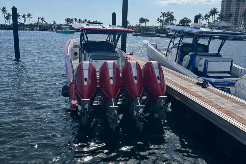 Slide: The Image of 2025 Nor-Tech 390 Sport boat with four red outboard engines docked at marina. - 12